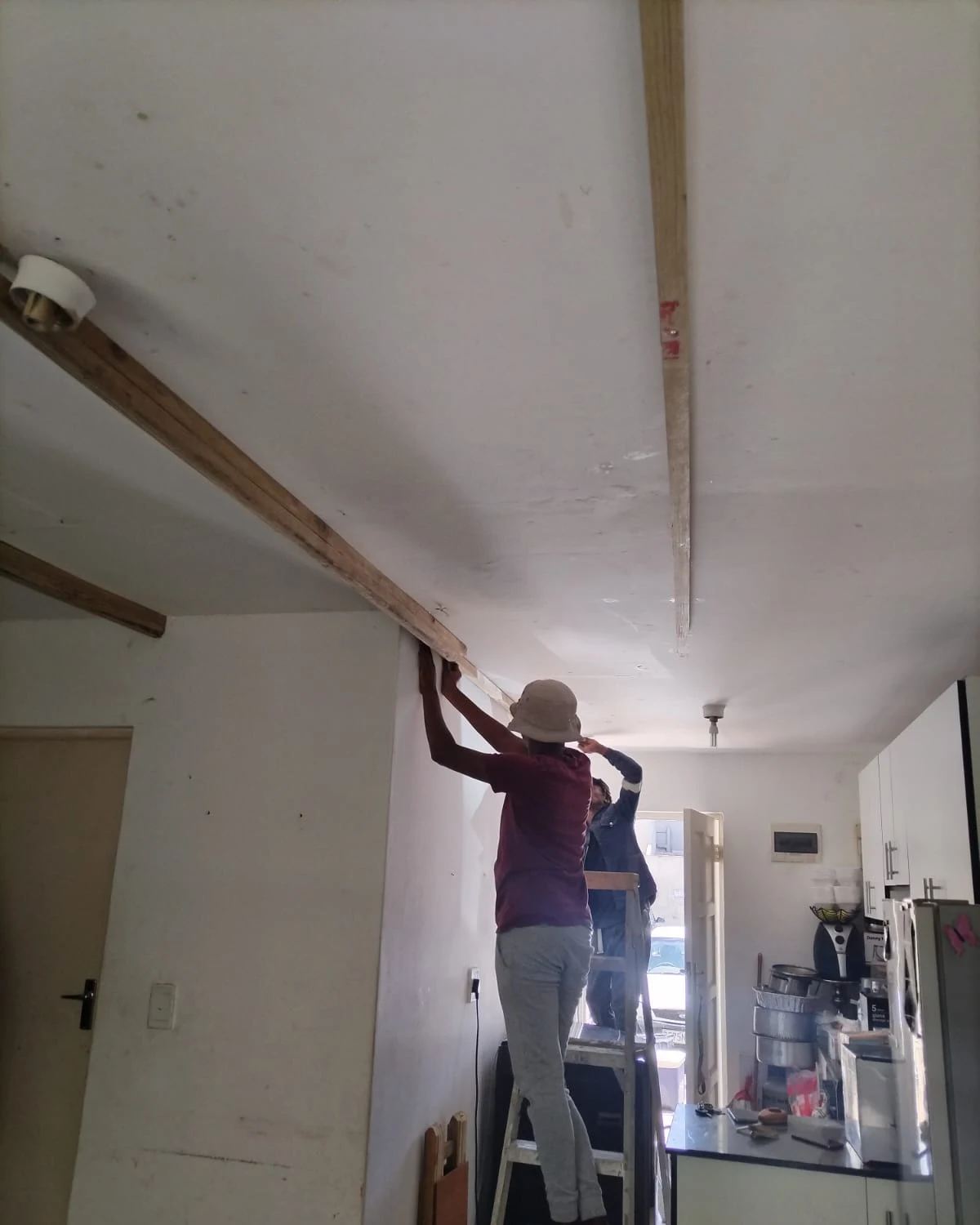 Timber ceiling brandering framework being installed by carpenters