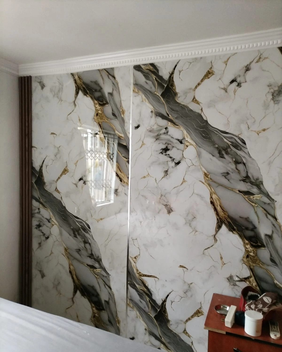 High-gloss bookmatched marble wall panels with gold veins
