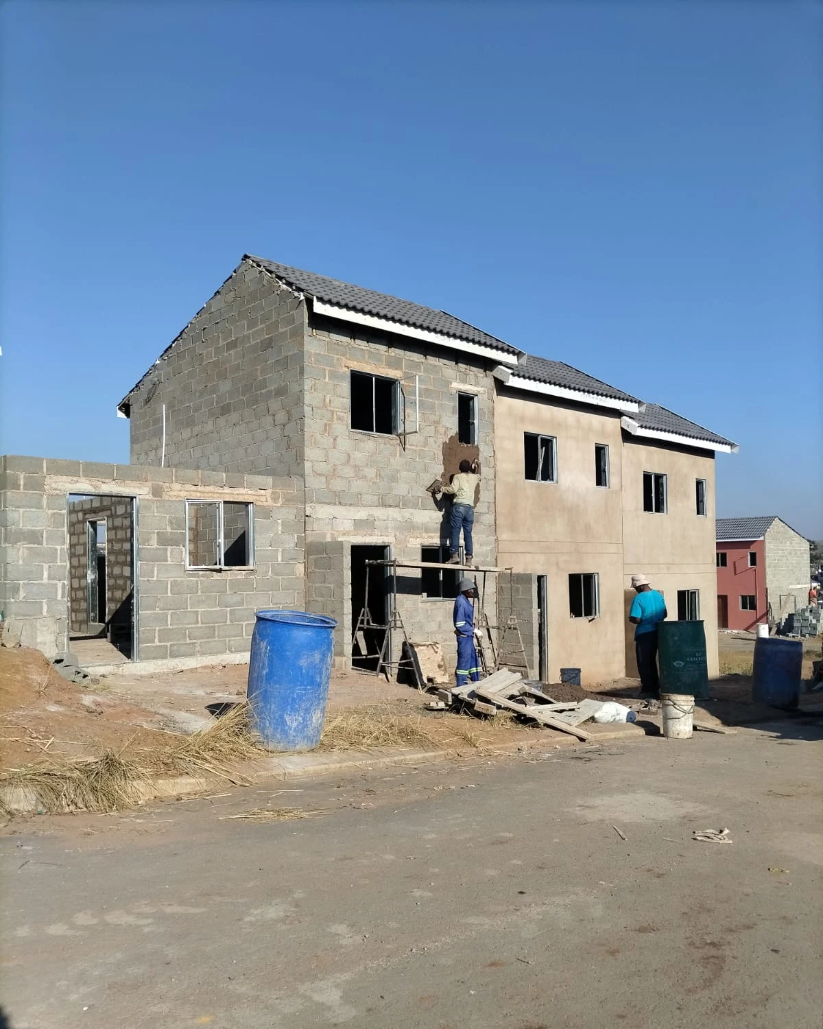 On-site team plastering townhouse block exterior
